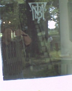 A dim reflection of myself taking a photograph of the door of Kisinoaks on a family unpaid work day.