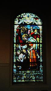 Window in the Saint Louis Cathedral in New Orleans showing the sainted King of France for whom the church is named caring for the sick directly.